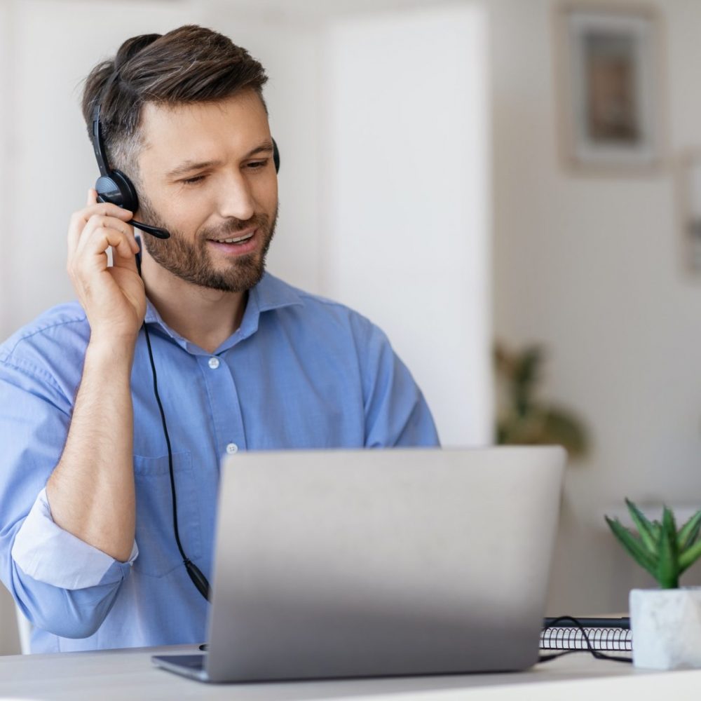 Hotline Operator. Portrait Of Call-Center Employee Wearing Headset At Workplace In Office